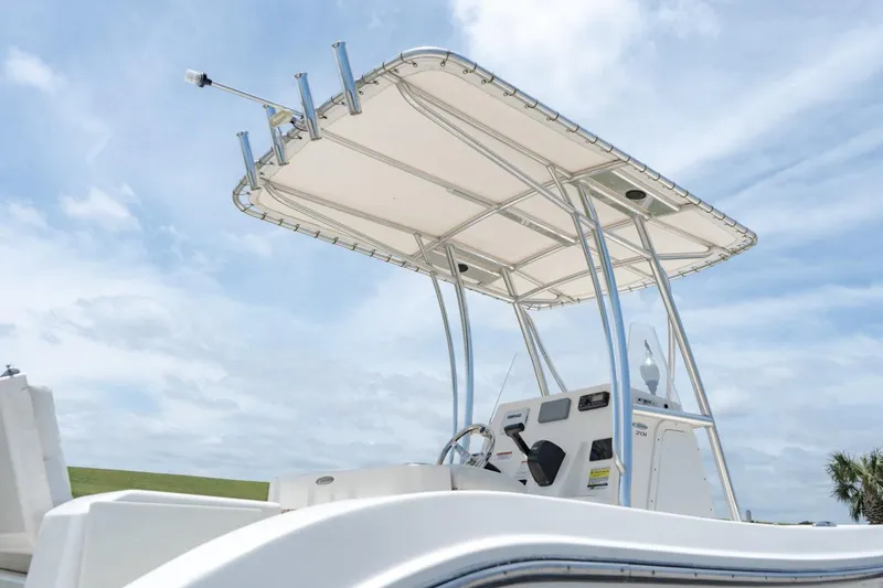 Slide: The Image of 2021 Cobia 201 Center Console boat with T-top against blue sky. - 16