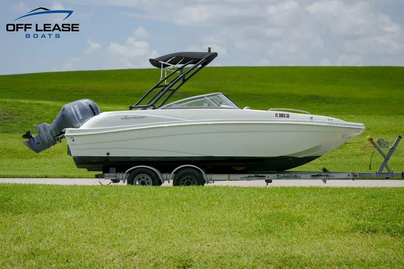 Slide: The Image of 2020 Hurricane 217 SD boat on trailer with outboard motor, Off Lease Boats logo. - 2