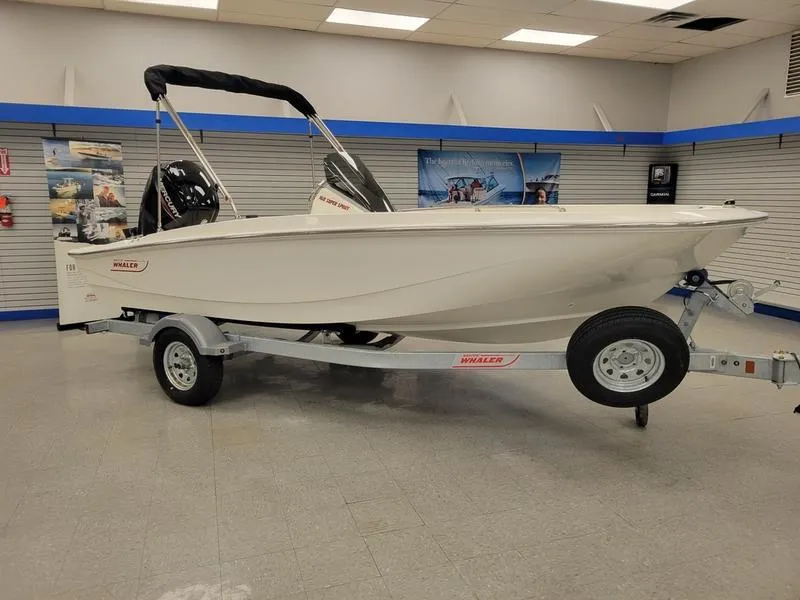 Slide: The Image of 2025 Boston Whaler 160 Super Sport boat displayed indoors on a trailer. - 0