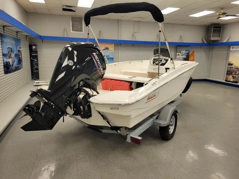 Slide: The Image of 2025 Boston Whaler 160 Super Sport boat displayed indoors on a trailer. - 1