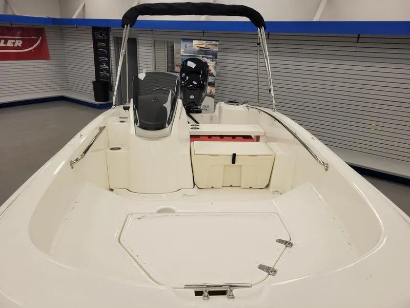 Slide: The Image of 2025 Boston Whaler 160 Super Sport boat interior, showcasing seating and steering console. - 2