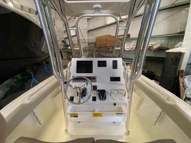 Slide: The Image of 2024 Key West 239 FS boat console with steering wheel and controls in a warehouse setting. - 4