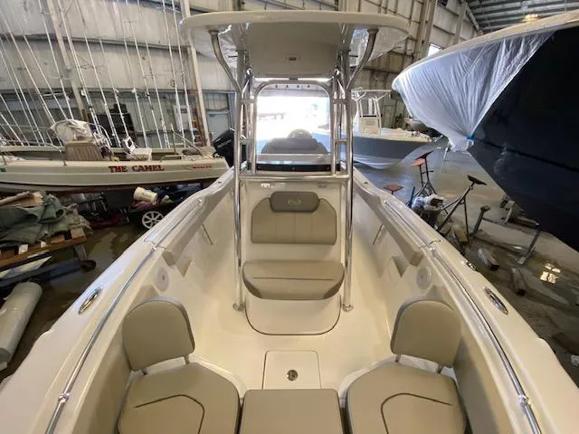 Slide: The Image of 2024 Key West 239 FS boat interior in a storage facility, showcasing seating and helm. - 7