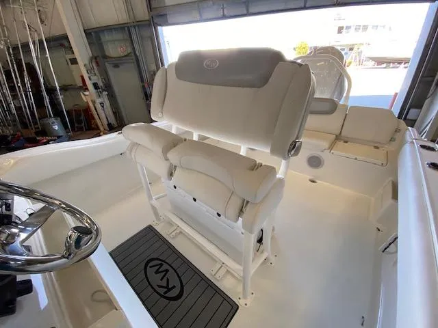 Slide: The Image of 2024 Key West 239 FS boat interior with cushioned seating and steering wheel. - 10