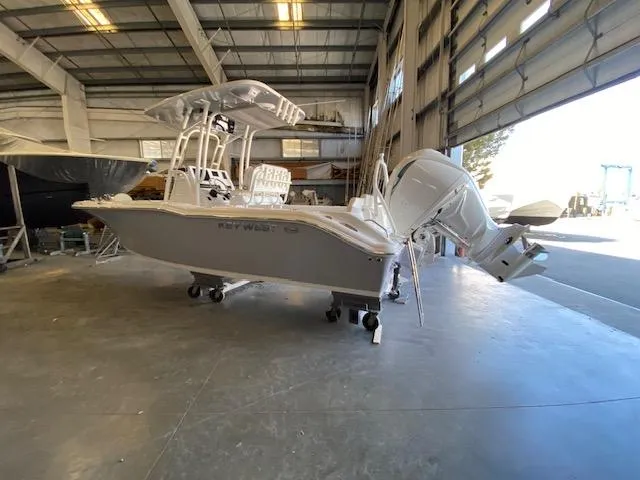 Slide: The Image of 2024 Key West 239 FS boat in a warehouse, side view with outboard motor. - 2