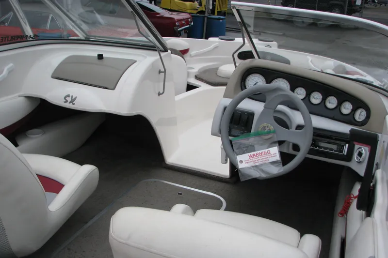 Slide: The Image of 1999 Glastron 175SX boat interior with steering wheel, dashboard, and seating. - 10