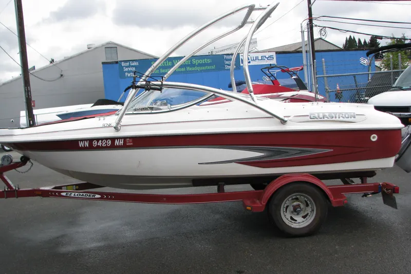 Slide: The Image of 1999 Glastron 175SX boat on trailer, red and white design, parked outdoors. - 15