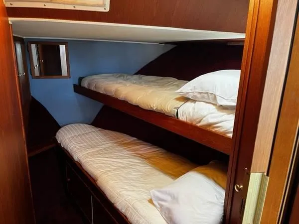 Slide: The Image of 1982 Uniflite Sport Fisher cabin with wooden bunk beds and cozy bedding. - 11