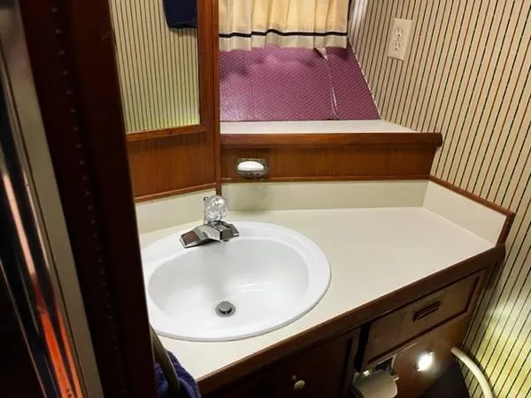 Slide: The Image of 1982 Uniflite Sport Fisher bathroom with sink, mirror, and wood accents. - 13