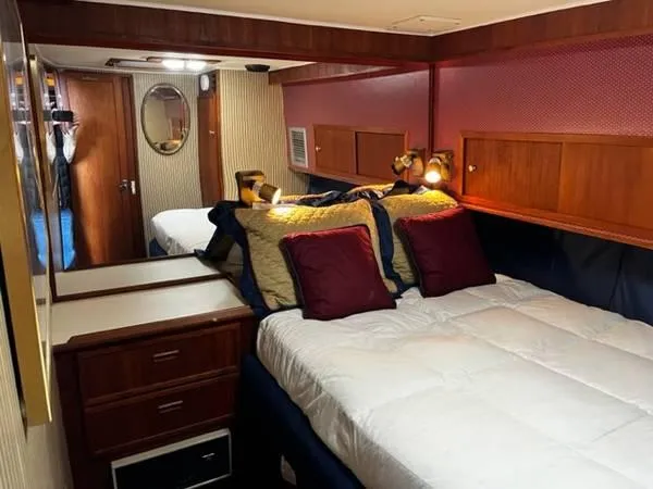 Slide: The Image of 1982 Uniflite Sport Fisher cabin with cozy bed, wooden cabinets, and ambient lighting. - 16