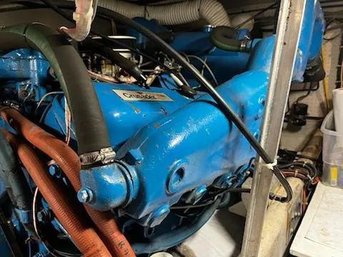 Slide: The Image of 1982 Uniflite Sport Fisher engine, blue with visible hoses and wiring in a boat's engine room. - 18
