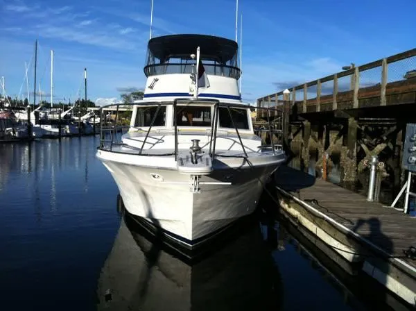 Slide: The Image of 1982 Uniflite Sport Fisher boat docked at marina under clear blue sky. - 2