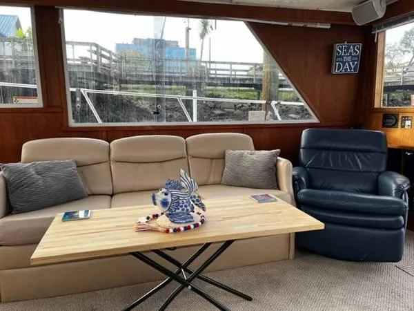 Slide: The Image of Interior of 1982 Uniflite Sport Fisher with beige sofa, wooden table, and decorative fish sculpture. - 7