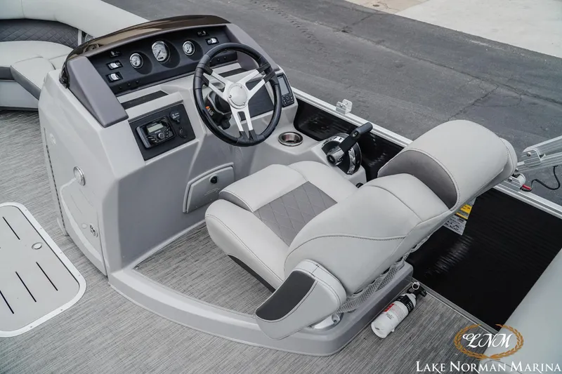 Slide: The Image of 2023 Bennington 23LSR boat helm with steering wheel and captain's chair at Lake Norman Marina. - 7