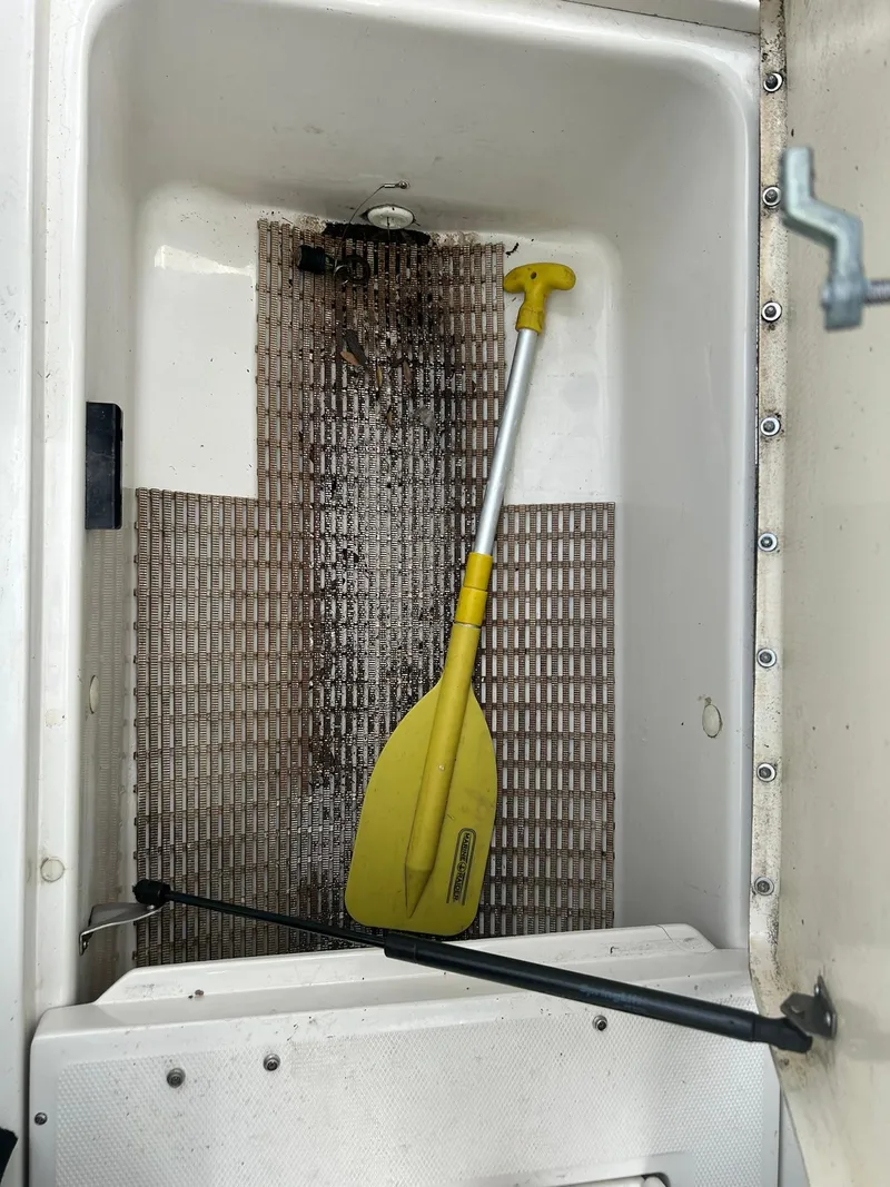 Slide: The Image of Storage compartment of 2008 Sea Ray 205 Sport with yellow paddle inside. - 14