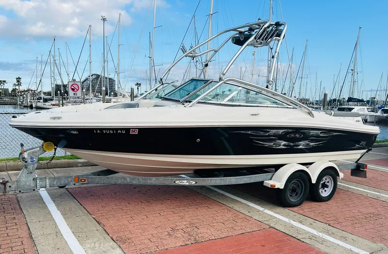 Slide: The Image of 2008 Sea Ray 205 Sport boat on trailer at marina with sailboats in background. - 2