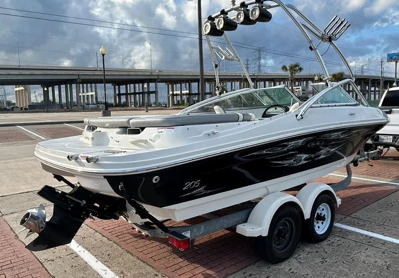 Slide: The Image of 2008 Sea Ray 205 Sport boat on trailer, parked outdoors under cloudy sky. - 4