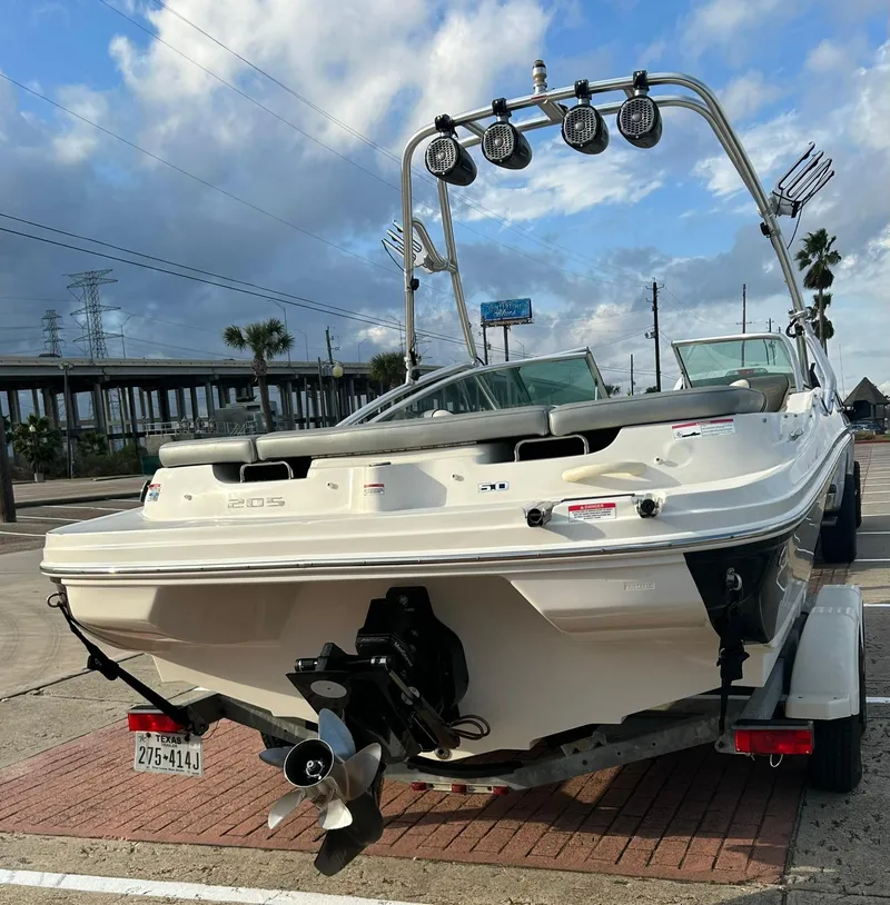 Slide: The Image of 2008 Sea Ray 205 Sport boat on trailer, parked outdoors under a cloudy sky. - 5