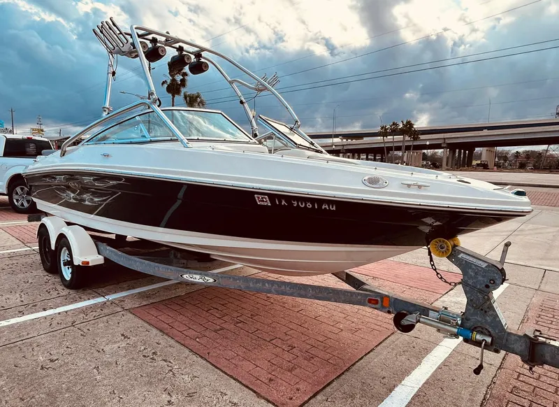 Slide: The Image of 2008 Sea Ray 205 Sport boat on trailer, parked outdoors under cloudy sky. - 7