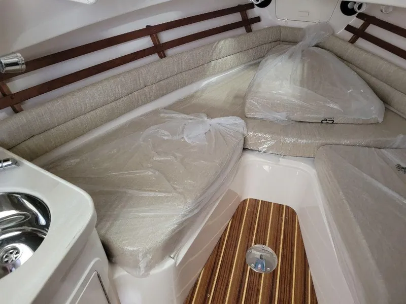 Slide: The Image of 2024 Grady-White Marlin 300 cabin interior with cushioned seating and wooden flooring. - 14