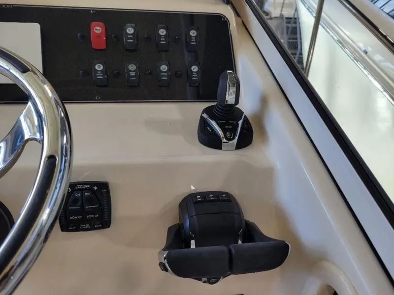 Slide: The Image of Control panel of 2024 Grady-White Marlin 300 boat with steering wheel and throttle. - 24