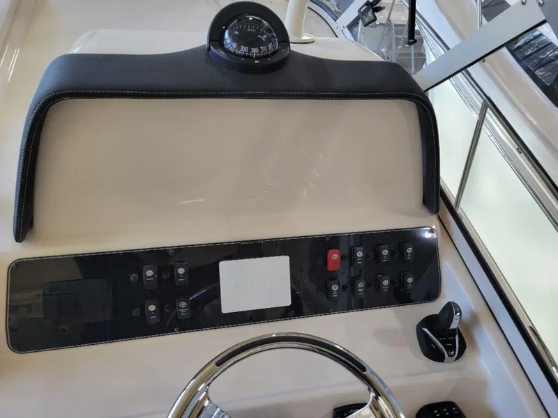 Slide: The Image of Control panel of a 2024 Grady-White Marlin 300 boat with compass and steering wheel. - 25