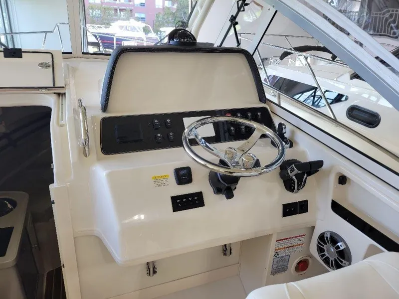 Slide: The Image of 2024 Grady-White Marlin 300 helm station with steering wheel and control panel. - 8