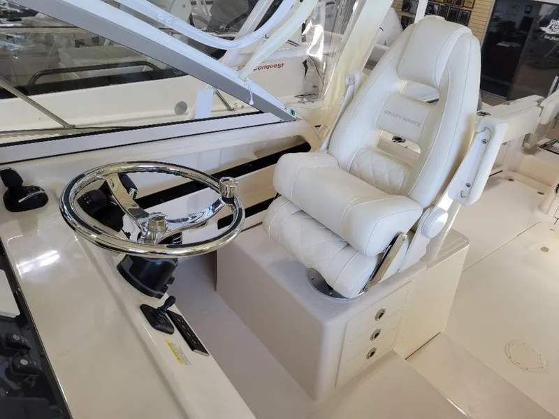 Slide: The Image of 2024 Grady-White Marlin 300 helm station with luxurious captain's chair and steering wheel. - 9