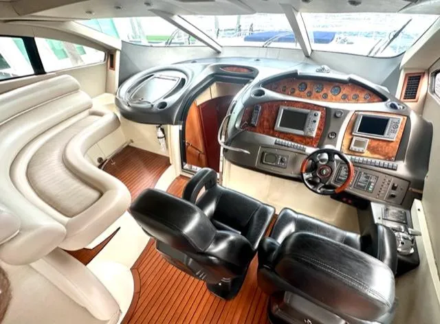 Slide: The Image of Interior of 2002 Sunseeker 75 Predator yacht with luxurious seating and advanced navigation controls. - 9