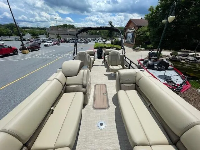 Slide: The Image of 2024 Regency 230 DL3 pontoon boat with beige seating and spacious deck. - 2