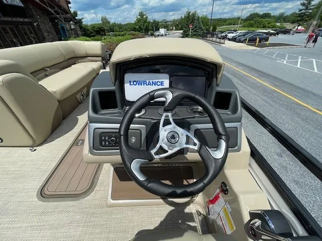 Slide: The Image of 2024 Regency 230 DL3 boat dashboard with steering wheel and Lowrance display. - 4