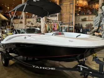 Slide: The Image of 2024 Tahoe T16 boat with canopy displayed indoors. - 2