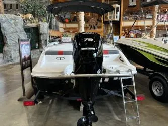 Slide: The Image of 2024 Tahoe T16 boat displayed indoors with motor and ladder. - 3