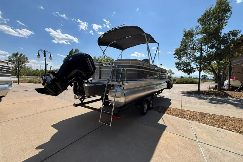 Slide: The Image of 2024 Sun Tracker Party Barge 24 DLX pontoon boat parked outdoors under clear sky. - 14