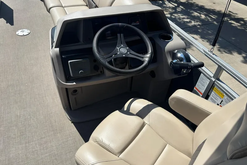 Slide: The Image of 2024 Sun Tracker Party Barge 24 DLX helm with steering wheel and beige seating. - 8