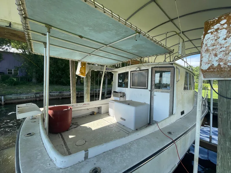 Slide: The Image of 1995 Stuart Angler 33 Downeast boat docked, covered deck, and fishing equipment. - 3