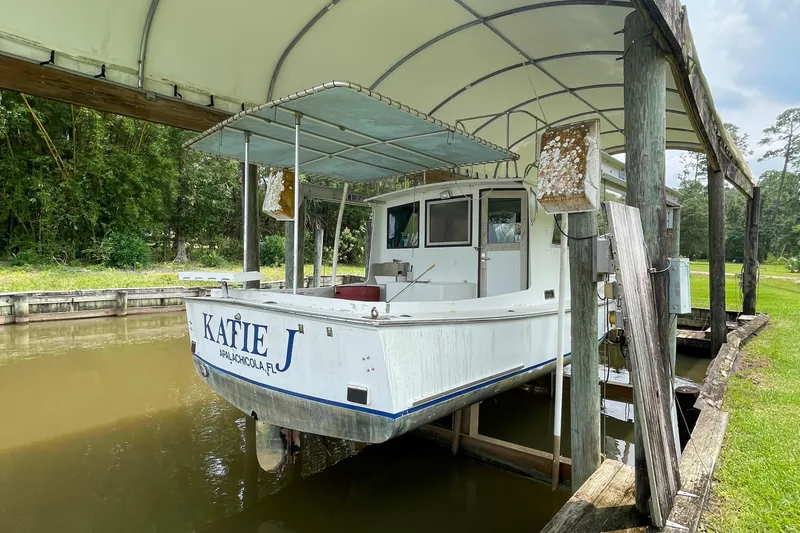 Slide: The Image of 1995 Stuart Angler 33 Downeast boat Katie J docked under a canopy. - 4