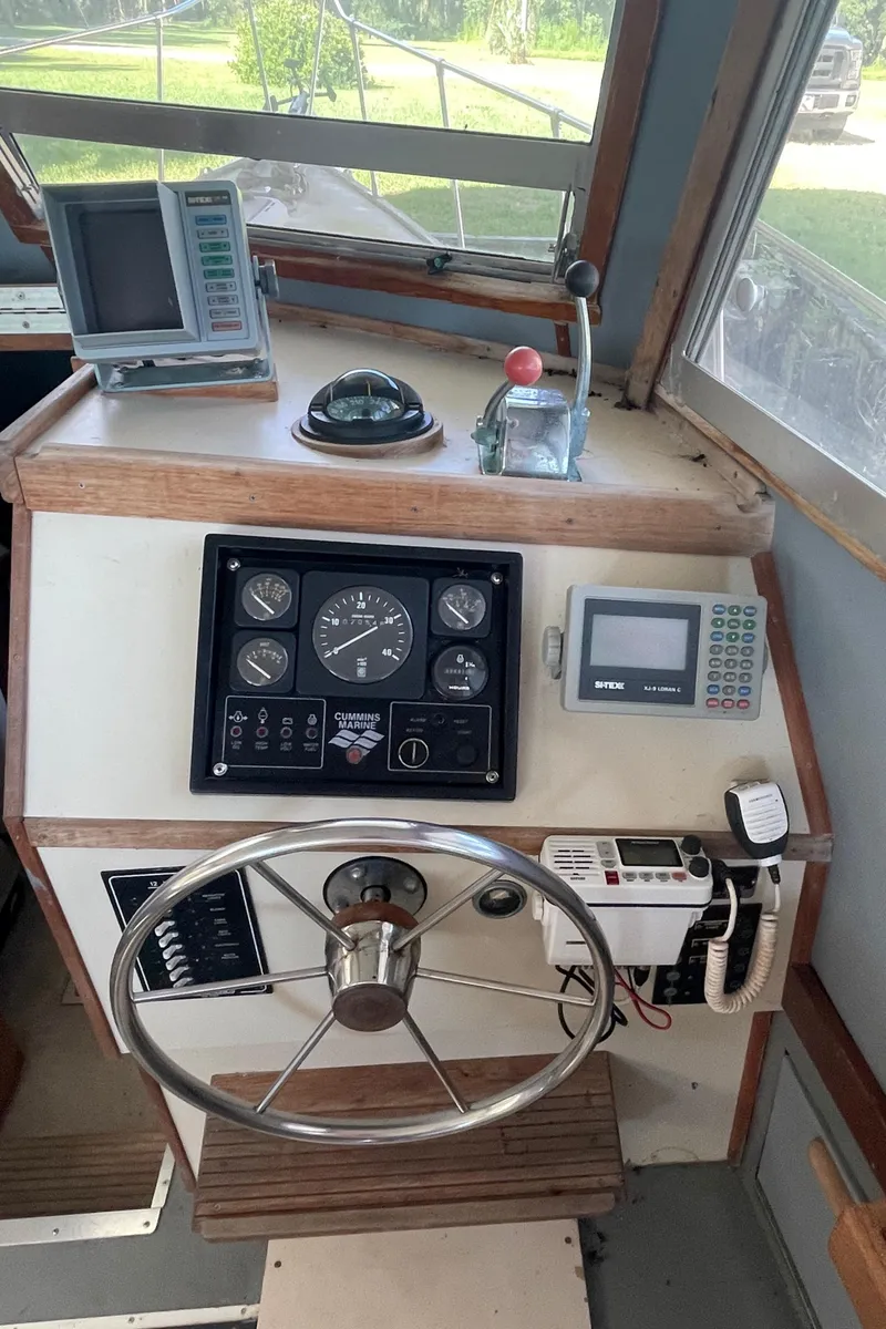 Slide: The Image of 1995 Stuart Angler 33 Downeast boat helm with navigation instruments and steering wheel. - 5