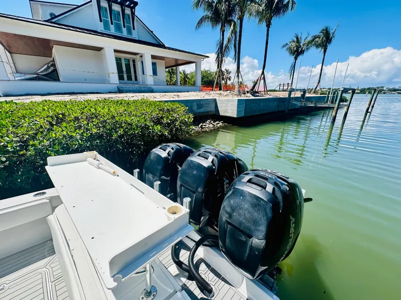 Slide: The Image of 2000 Luhrs Tournament 320 Open boat docked near waterfront house with palm trees. - 16