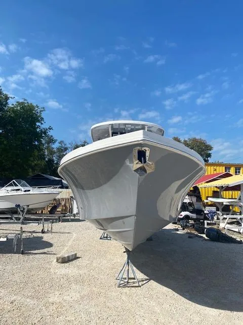 The Image of 2024 Parker 2900 CC boat on stands in a boatyard under a clear sky. - 0