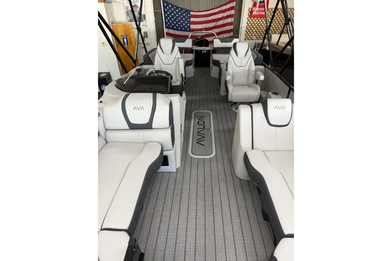 Slide: The Image of 2025 Avalon 2385 Catalina QLS boat interior with luxurious seating and American flag backdrop. - 7
