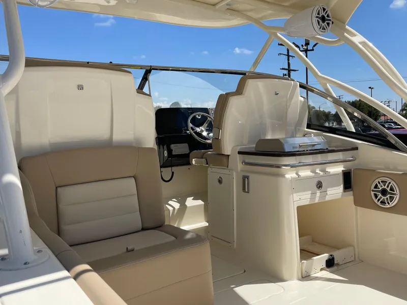 Slide: The Image of 2024 Scout 255 Dorado boat interior with beige seating and modern helm. - 2