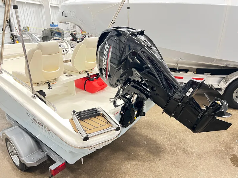 Slide: The Image of 2024 Boston Whaler 130 SPT boat with Mercury outboard motor in a showroom. - 2