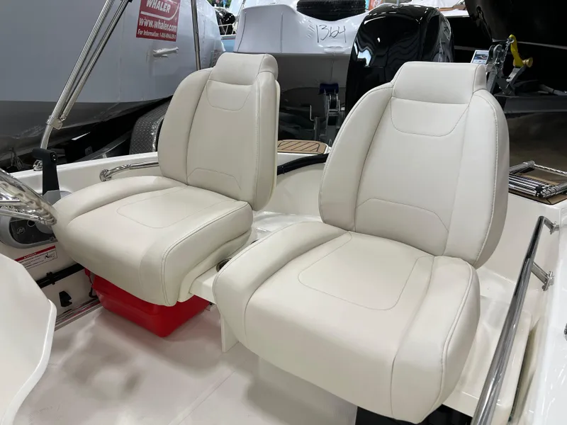 Slide: The Image of 2024 Boston Whaler 130 SPT boat with white cushioned seats. - 3