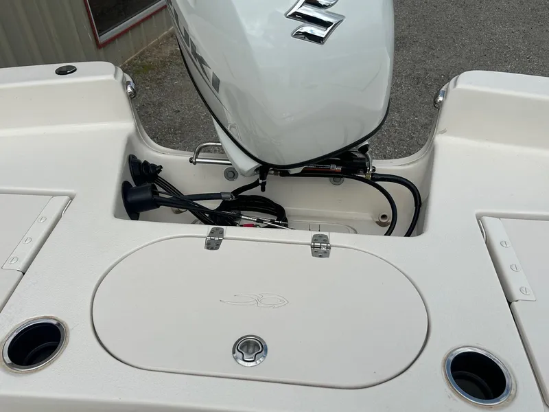 Slide: The Image of 2024 Carolina Skiff 19 LS boat with Suzuki outboard motor and storage compartment. - 17