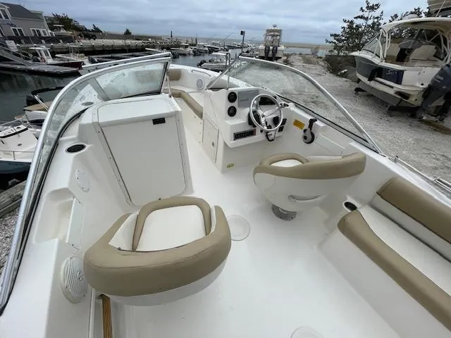 Slide: The Image of 2019 Key West 203 DFS boat interior with beige seating, steering wheel, and dashboard. - 8
