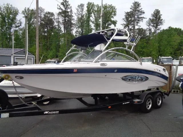The Image of 2005 Nautique Air 226 boat on trailer, white and blue, with wakeboard tower. - 0