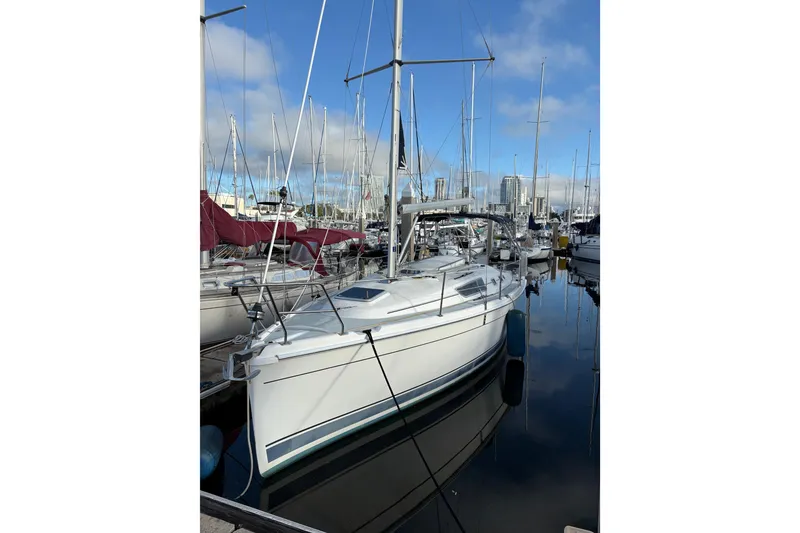 The Image of 2009 Hunter 31-2 sailboat docked in a marina under a clear blue sky. - 0