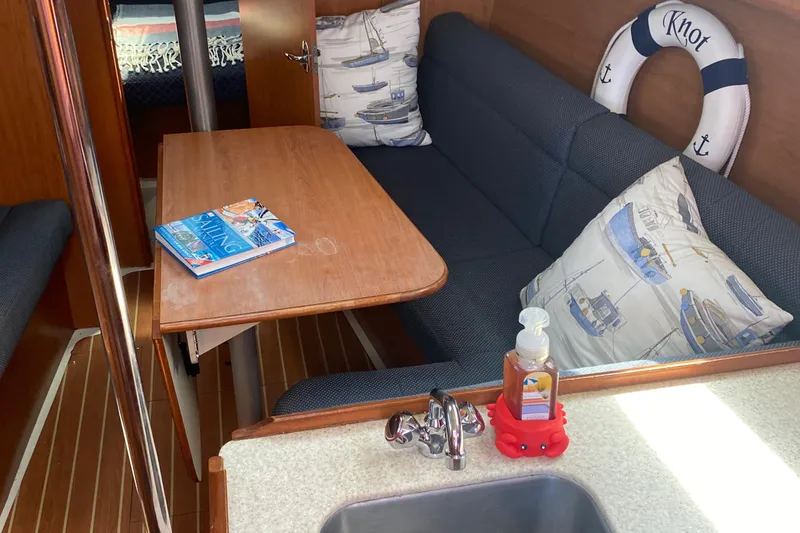 Slide: The Image of Interior of a 2009 Hunter 31-2 sailboat with a cozy seating area and table. - 18