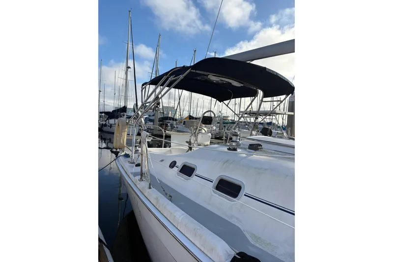 Slide: The Image of 2009 Hunter 31-2 sailboat docked at marina, featuring sleek design and blue canopy. - 23